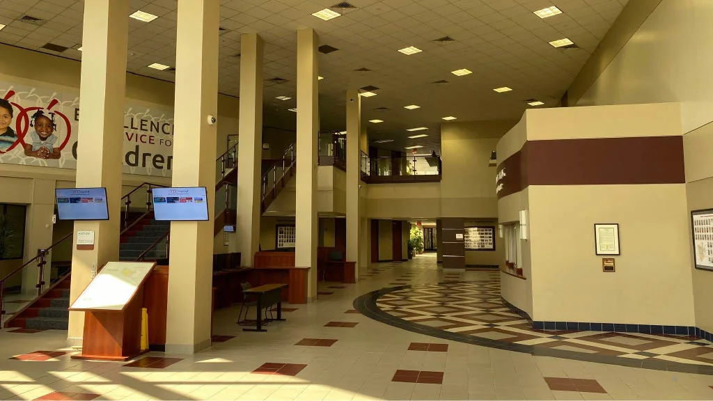 Original conference-center lobby with exposed columns and patterned flooring.